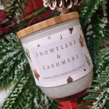 Load image into Gallery viewer, Candle with 'Snowflake & Cashmere' label on a Christmas-themed background