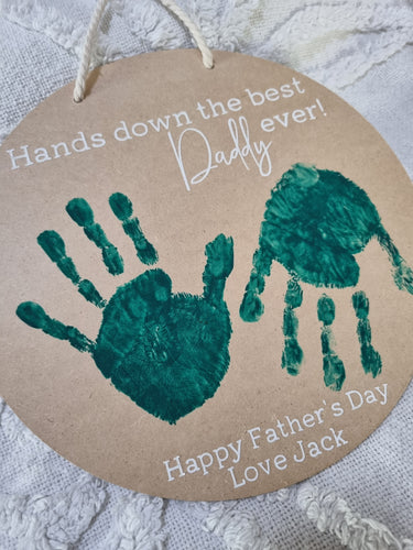 A personalized wooden hanging sign with painted handprints and the text 'Hands down the best Daddy ever! Happy Father's Day Love Jack'.