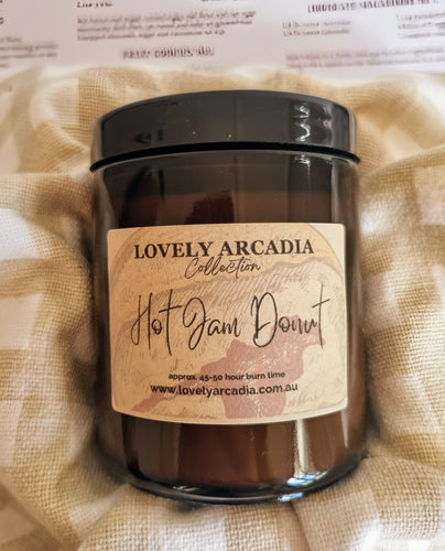 Candle jar with 'Lovely Arcadia' label on a textured beige fabric background