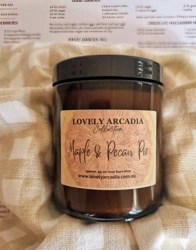 Candle jar with 'Lovely Arcadia' label on a textured fabric background