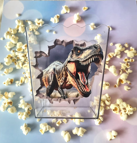 Dinosaur design on a clear box with popcorn around it