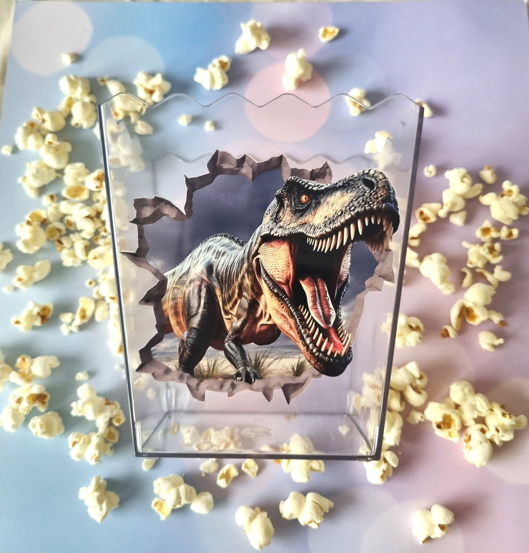 Dinosaur design on a clear box with popcorn around it