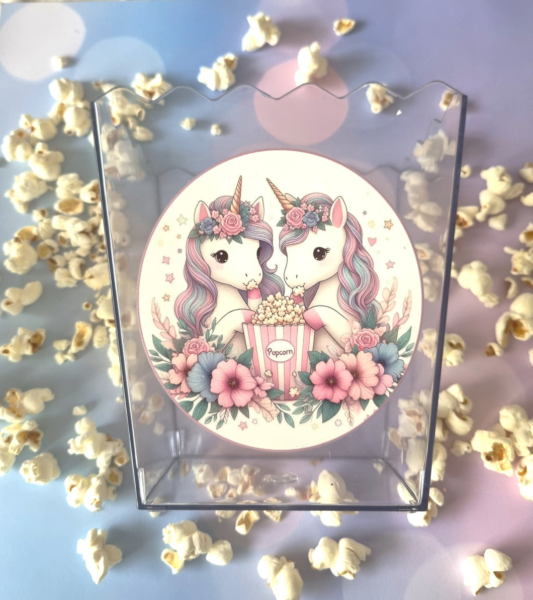 Unicorn-themed popcorn box with flowers and popcorn on a light background