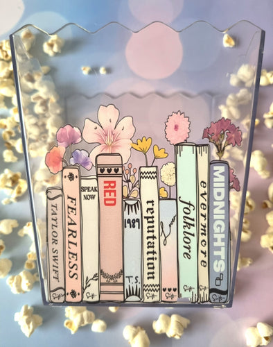 Illustrations of Taylor Swift album covers with flowers on a decorative background with popcorn.