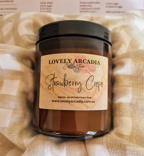 Candle with 'Lovely Arcadia' label on a textured beige fabric background