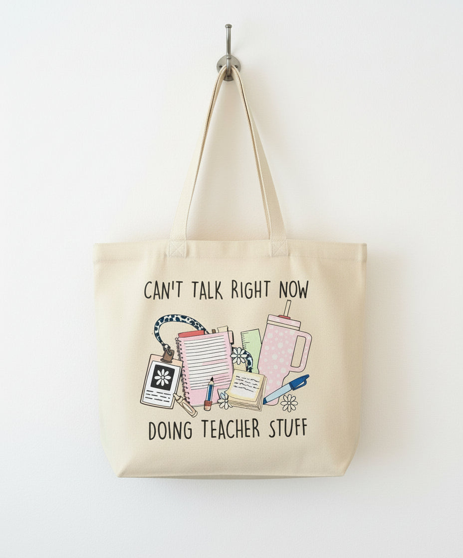 Beige tote bag with teacher-themed design and text on a checkered fabric background