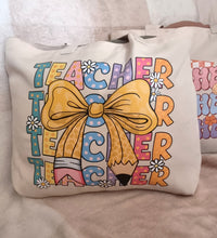 Load image into Gallery viewer, Tote bag with &#39;TEACHER&#39; text and a bow design on a neutral background
