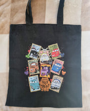 Load image into Gallery viewer, Black tote bag with colorful character designs and &#39;Trick or Treat&#39; text on a striped fabric background.
